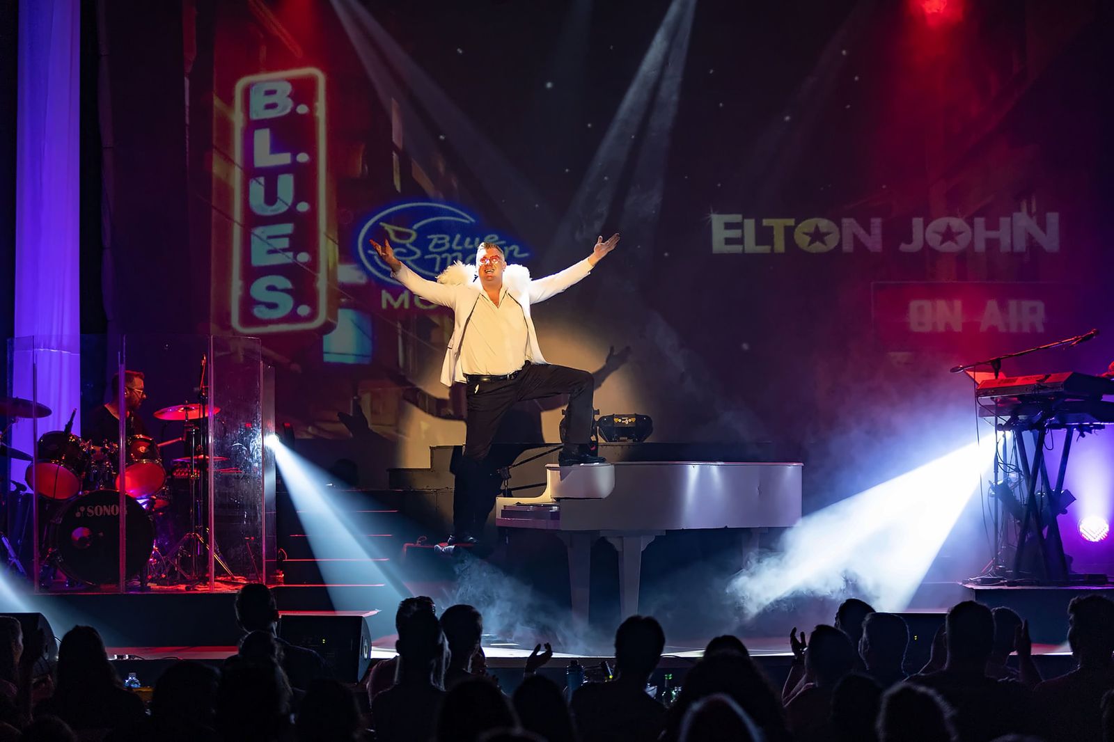 Evan performing with arms outstretched on stage