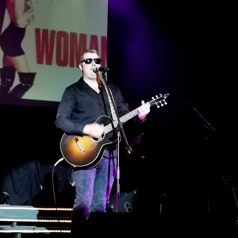 Evan singing with an acoustic guitar